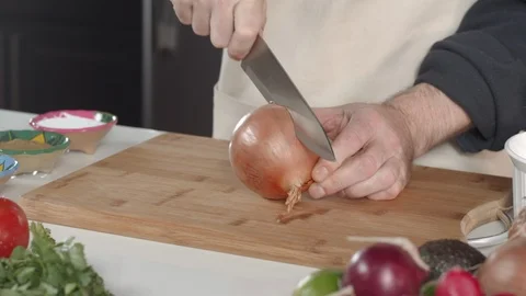 Tracking shot of chef slicing and peeling yellow onion in kitchen Vídeo Stock 92054213