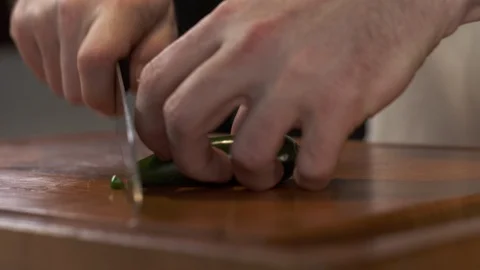 Tracking shot of chef slicing fresh jalapeno pepper Видео 92177071