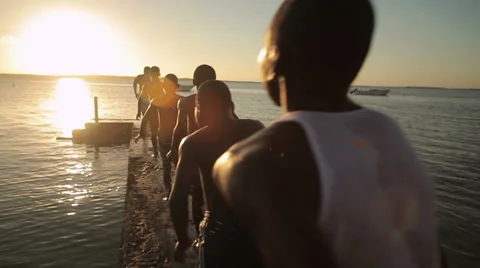 Tracking shot of children running off a dock Stock Footage 36000346