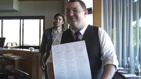 Tracking shot of a couple sitting down in a restaurant Stock Footage 76538976