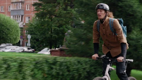 Tracking shot of cyclist riding through city streets 库存影片 317561909