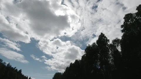 Tracking shot of dramatic clouds drifting across sky with sun partially hidden Stock Footage 318923462