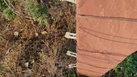 Tracking Up Shot of Electric Fence Post with Insulators and Wire System Stock Footage 337978097