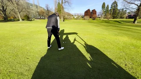 Tracking Shot on an Elegant Golfer Making a Practice Golf Swing on the Fairway Stock Footage 265216756