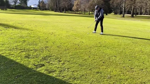 Tracking Shot on an Elegant Golfer Making a Practice Golf Swing on the Fairway Stock Footage 265216769