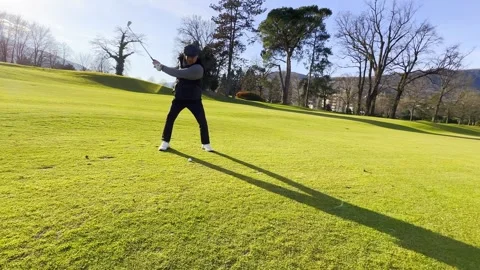 Tracking Shot on an Elegant Golfer Making a Golf Swing and Hitting the Golf Ball Stockbeeldmateriaal 271357538