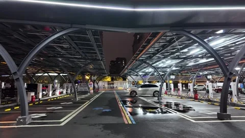 Tracking Shot of EV Leaving High-Tech Charging Hub at Night Video stock 330883578