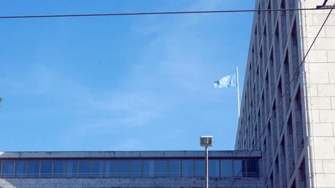 Tracking shot on the facade, with the flag of the Fao waving in the blue sky Stock Footage 88320331