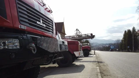 Tracking shot of fire engines stand outside near fire station. Video stock 128661448