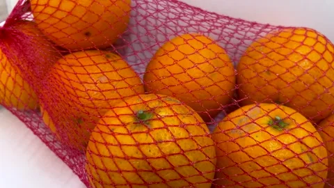 Tracking shot on fresh oranges in net bag Stock Footage 301928322