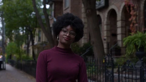 Tracking shot of funky young black woman walking down city street Stock Footage 88829734