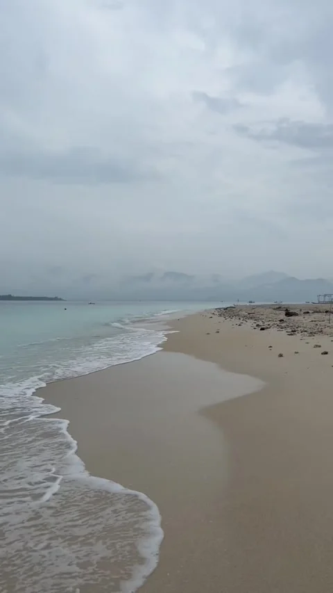 Tracking shot gentle waves lapping serene sandy beach at dusk Vidéo 333605296