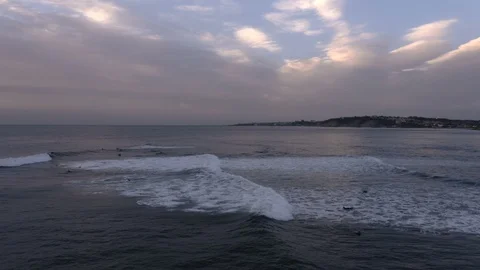Tracking shot of giant waves at dusk as surfers wait Stock Footage 112695178