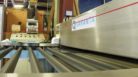 Tracking shot of glass coming out of machine in factory Stock Footage
