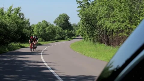 Tracking shot of a group of cyclists on country road. Vidéo 142876252