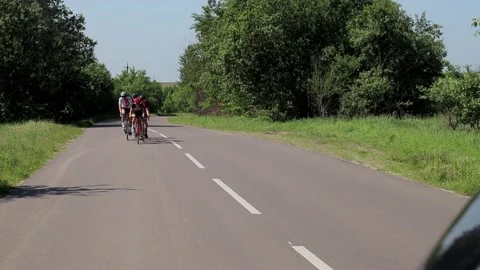 Tracking shot of a group of cyclists on country road. 動画素材 142877271