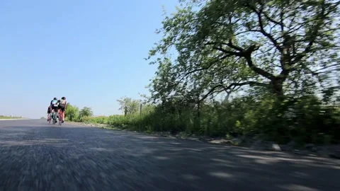 Tracking shot of a group of cyclists on country road. 動画素材 142878876