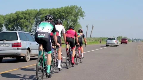 Tracking shot of a group of cyclists on country road. Vidéo 142882796
