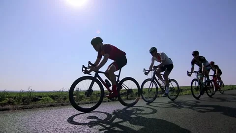 Tracking shot of a group of cyclists on country road. Vídeo Stock 142883285