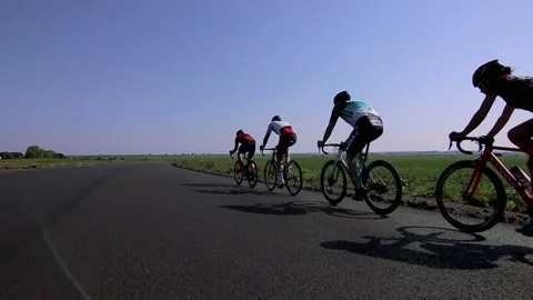 Tracking shot of a group of cyclists on country road. Stock Footage 142883306