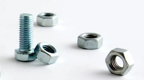 Tracking shot of a group of nuts surrounding one bolt. Video stock 58861770