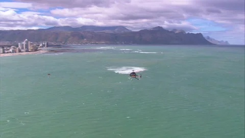 Tracking shot of a helicopter flying adjacent Strand Beach Stock Footage 310544161