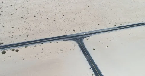 Tracking shot highlights road traversing desert environment drone aerial 4K Stock Footage 111309212