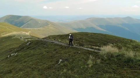 Tracking shot of hiker walking on mountain trail Drone shot of young man hiking Stock Footage 102465036