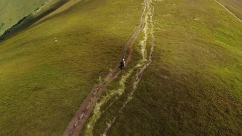 Tracking shot of hiker walking on mountain trail Drone shot of young man hiking Stock Footage 102465497