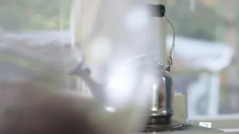 Tracking shot of hispanic man grabbing tea kettle off stove Stock Footage 84451734