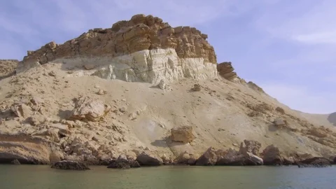 Tracking shot from inside water of sandy cliffs of a beautiful remote beach Stock Footage 111885768