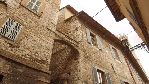 Tracking shot from iron gate to wall of Assisi stones Video stock 82107942