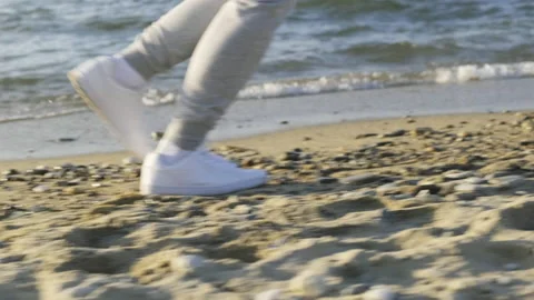 Tracking shot of the legs of a runner exercising on the beach. Stock Footage 196849360