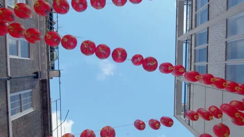 Tracking shot looking up at red Chinese lanterns dangling in Chinatown in London Stock Footage 148617873