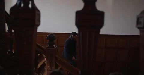 Tracking shot of a man walking down stairs of mansion Stock Footage 73251283