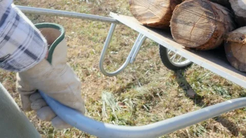 Tracking Shot of a Man's Gloved Hands Pushing a Wheelbarrow in 4k Stock Footage 86079501