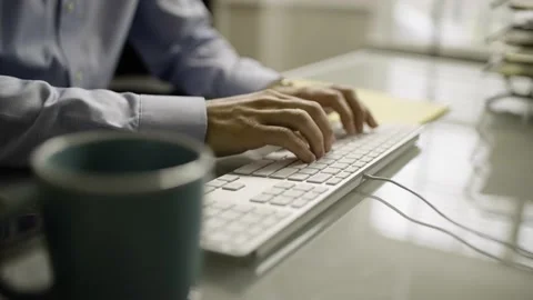 Tracking shot of man's hands typing on computer keyboard during the day Stock Footage 145724915