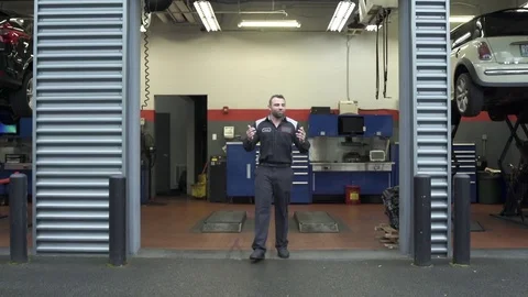 Tracking shot of a mechanic walking backwards 動画素材 76233385