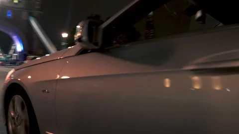 Tracking shot of a Mercedes E-Class car driving on London city streets at night Stock Footage 121618260