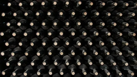 Tracking Shot of Old Aged Stacked Wine Bottles in a Cellar Video stock 256496082