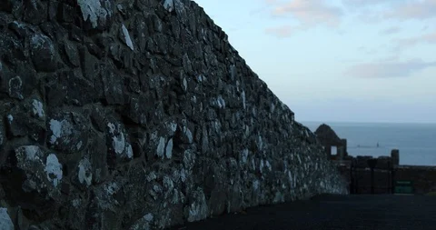 Tracking shot of an old stone wall in a historical castle in Northern Ireland Vídeos de archivo 101025663