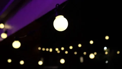 Tracking shot of one bulb on string lights Stock Footage 106846125