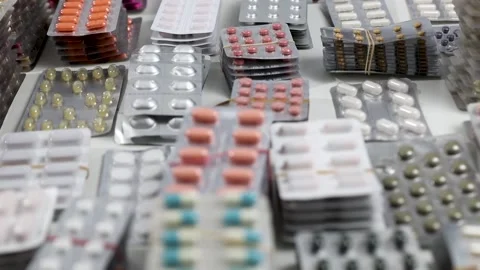 Tracking shot over desk full of pills in their blisters Stock Footage 154309027