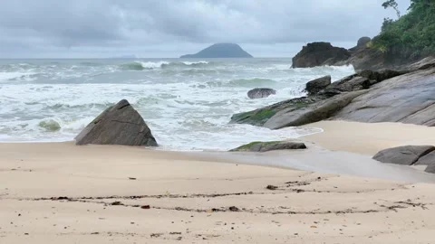 Tracking Shot Over Sandy Beach Towards Rocky Coastline and Ocean Horizon Stock Footage 347222139
