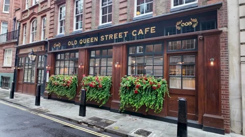 Tracking shot past Old Queen Street Cafe frontage on narrow London street Stock Footage 346678287
