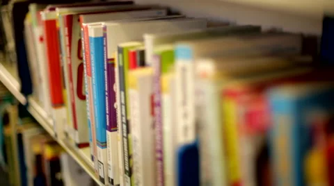 Tracking Shot Past Someone Choosing Books 2 Stock Footage 44250166
