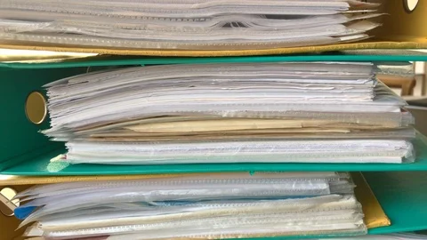 Tracking shot of piles of binders in different colors filled with documents Stock Footage 105963864