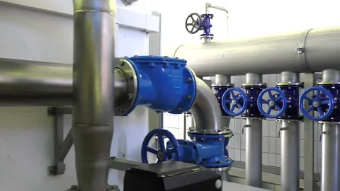 Tracking shot of a pipe system with shut-off valves in the waterworks Stock Footage 234998574