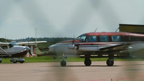 Tracking Shot Piper Twin Engine Plane Taxiing Along Runway at a Small Stock Footage 99376175