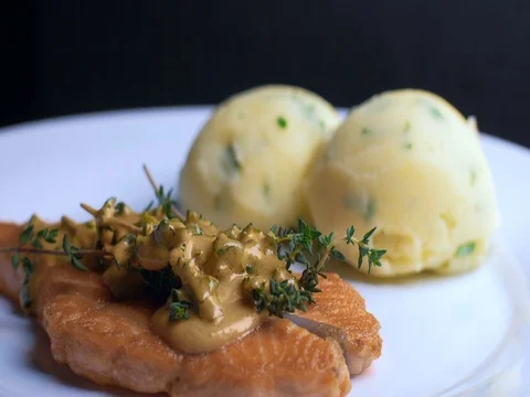 Tracking shot of pouring sauce over the top of salmon steak on white plate Stock Footage 84942373